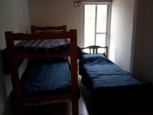 two bunk beds in a room with a window at San martin 304 in Balcarce