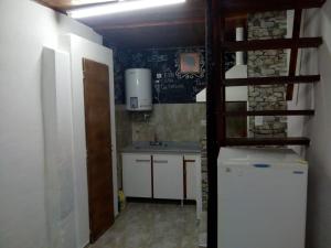 a small kitchen with a sink and a refrigerator at San martin 304 in Balcarce