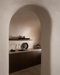 an archway in a kitchen with a sink at Vora in Imerovigli