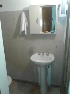 ein Badezimmer mit einem Waschbecken, einem Spiegel und einem WC in der Unterkunft San martin 304 in Balcarce