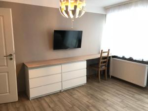 a room with a desk with a tv and a chair at Ferienwohnung am Uniklinik in Lübeck