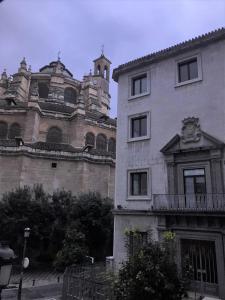 a building with a clock tower in front of it at Casa Montalbán Apartamentos Turísticos in Granada