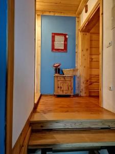 a hallway with a blue wall and a wooden floor at Siedlisko Zakucie in Jaśliska