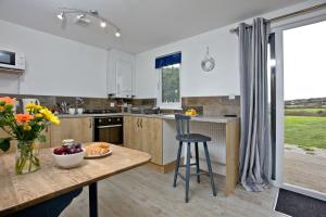 a kitchen with a table with a bowl of fruit at Wheal Tor- Beautifully Fitted Wooden Lodge Helston Cornwall in Helston