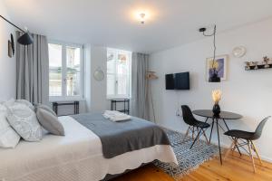 a bedroom with a bed and a table and chairs at Porto Center Apartments in Porto