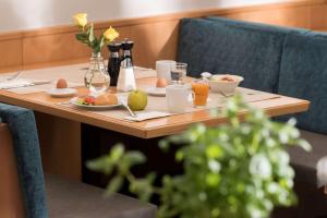 uma mesa de madeira com comida e bebidas para o pequeno-almoço em Ramada by Wyndham Hannover em Hanôver