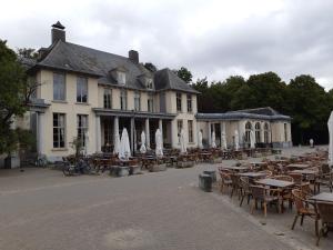 un groupe de tables et de chaises devant un bâtiment dans l'établissement casa di Gino, à Anvers