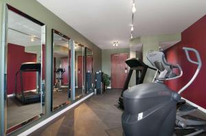 a gym with a treadmill and a room with mirrors at Travelodge by Wyndham Stony Plain in Stony Plain