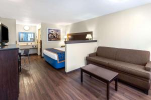 a small hotel room with a bed and a couch at Days Inn by Wyndham Grants in Grants