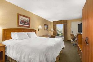 um quarto de hotel com uma cama grande e uma televisão em Howard Johnson by Wyndham Greensboro Near the Coliseum em Greensboro