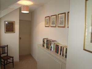 a hallway with a book shelf with books at Cleaver Cottage in Andover