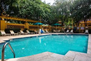 a large blue swimming pool with chairs and umbrellas at La Quinta by Wyndham Charlotte Airport South in Charlotte