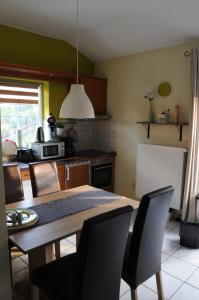 eine Küche mit einem Holztisch und Stühlen sowie einem Tisch und einer Küche in der Unterkunft Haus Vis a Vis 1 in Stromberg