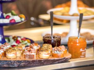 a plate of pastries on a table with jams at Mercure Toulouse Centre Saint-Georges in Toulouse