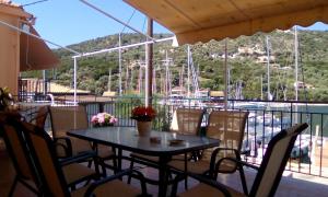 a table and chairs on a balcony with a marina at Aristoula House in Sivota