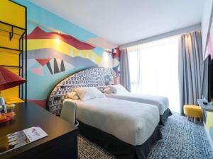 a bedroom with a large bed and a large window at ibis Styles Tbilisi Center in Tbilisi City