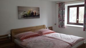 1 cama en un dormitorio con ventana en Haus 66 en Obertraun