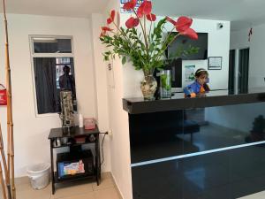 a woman standing at a counter in a room with flowers at Hotel Casa Guillermo in Bogotá