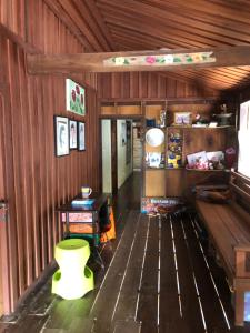 um quarto com piso em madeira e um banco verde em Fisherman Guesthouse em Ko Yao Noi