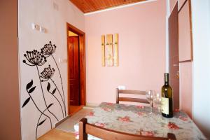 a dining room with a table and a bottle of wine at Apartments Jeca in Zlatibor