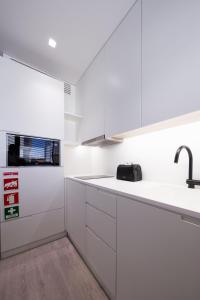 a kitchen with a white counter top and white cabinets at BessaApartments in Porto