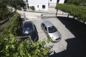 two cars parked next to each other in a driveway at Apartments Tea - parking and grill, 100 m from sea in Rogoznica