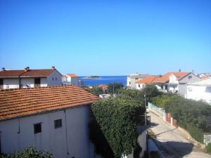 a view of a town with houses and the ocean at Apartments Tea - parking and grill, 100 m from sea in Rogoznica