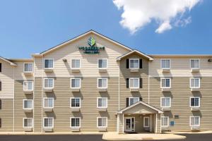麥迪遜的住宿－Woodspring Suites Huntsville/ Madison，一面有双 ⁇ 标志的大建筑