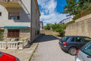 ein Auto, das auf einem Parkplatz neben einem Gebäude parkt in der Unterkunft Apartments Ana - private parking in Crikvenica