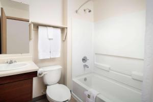 biała łazienka z toaletą i umywalką w obiekcie Woodspring Suites Huntsville/ Madison w mieście Madison