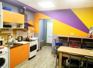 eine Küche mit farbenfrohen Wänden sowie einem Tisch und Stühlen in der Unterkunft Hostel Meridian in Kiew