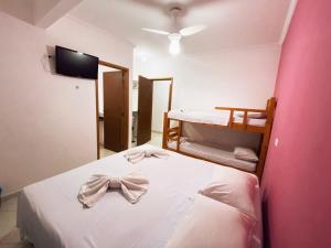 Un dormitorio con una cama con una pajarita. en Pousada Werneck Residence Suites, en Ubatuba 196 fotos más