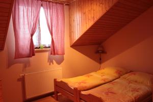 a bedroom with a bed and a staircase with windows at Rekreačný dom pod Dedovou in Oščadnica