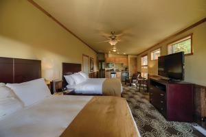 a hotel room with two beds and a flat screen tv at Explorer Cabins at Yellowstone in West Yellowstone