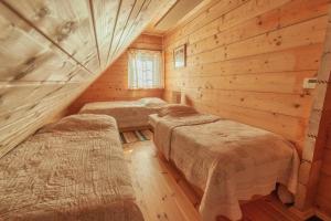 クルシュコフツェにあるChatki Qdłatkiのログキャビン内のベッドルーム1室(ベッド3台付)