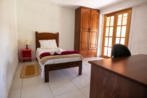 a bedroom with a bed and a desk in a room at Pousada Campina do Monte Alegre in Campina do Monte Alegre