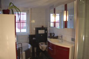 a bathroom with a sink and a toilet and a mirror at Ferienhaus Bogsi in Müllrose +39 photos