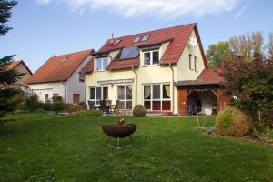 a house with a bird bath in the yard at Ferienhaus Bogsi in Müllrose