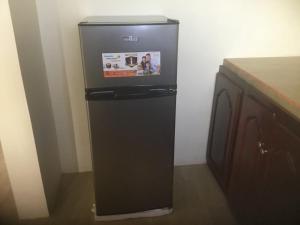 a black refrigerator with a tv on top of it at Solet's Paradise Negril in Negril