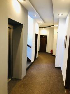 pusty korytarz z białymi ścianami i drzwiami w obiekcie Hotel Piast w Czeskim Cieszynie