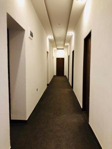 un pasillo con paredes blancas y un largo pasillo con puerta en Hotel Piast en Český Těšín