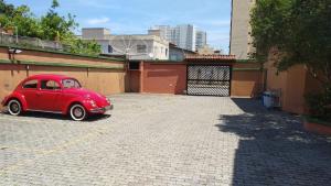 um velho carro vermelho estacionado num parque de estacionamento em Sobrado in Village no Guarujá