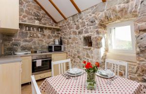 una cocina con una mesa con flores rojas. en Holiday home Gor - free WiFi, en Gata