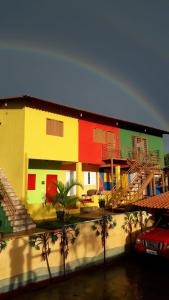 une maison colorée avec des palmiers devant elle dans l'établissement Atelier & Pousada Chapada, à Alto Paraíso de Goiás
