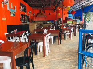 a restaurant with red walls and wooden tables and chairs at CANIBAD SECRET PARADISE RESORT in Aumbay