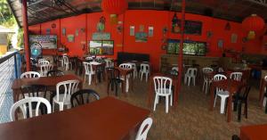 a restaurant with white chairs and tables and red walls at CANIBAD SECRET PARADISE RESORT in Aumbay +143 photos