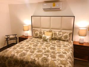 um quarto com uma cama grande e duas mesas de cabeceira com candeeiros em SKY INN Acapulco Y condominio mediterrane em Acapulco