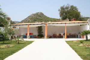 a white house with a patio with a table at Helios Hotel in Agia Marina Aegina