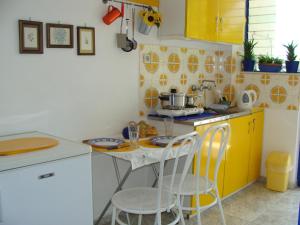 eine kleine Küche mit einem Tisch und gelben Schränken in der Unterkunft Helios Hotel in Agia Marina