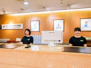 two people standing at a counter in a restaurant at Hotel Grand Terrace Obihiro in Obihiro